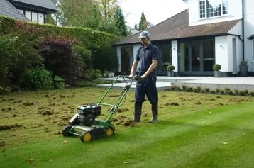 A man is using an electric mower to cut the grass.