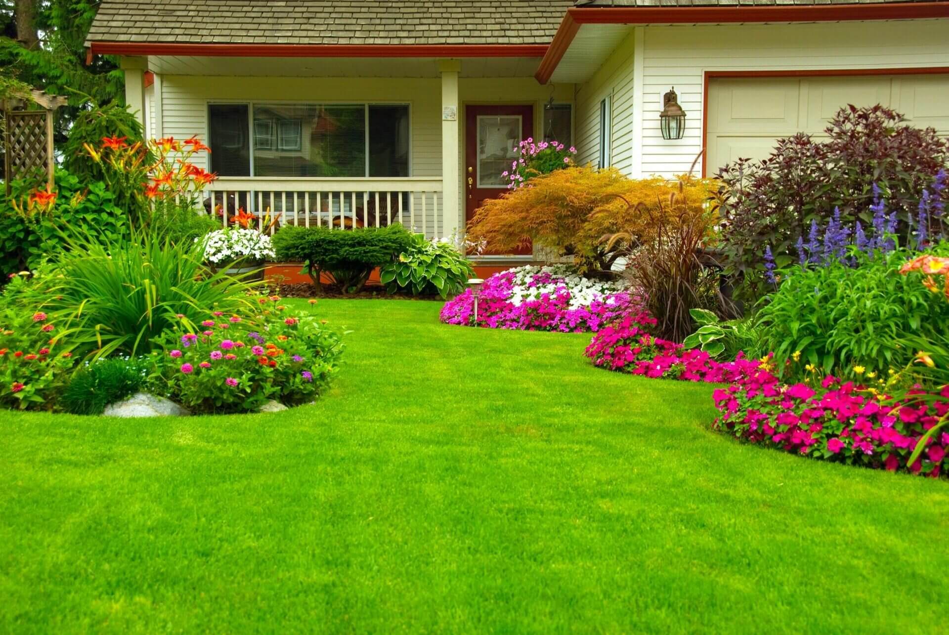 A Front Lawn With Flower Beds of Different Colors
