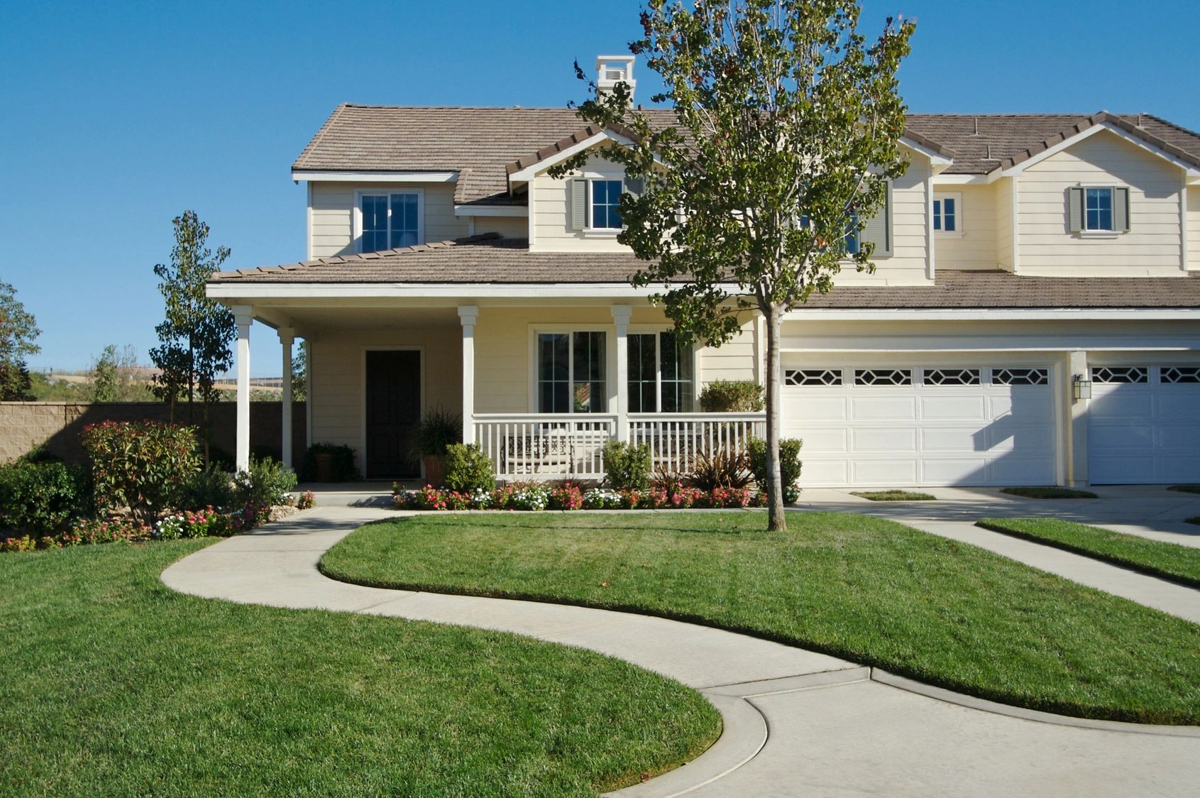 A house with a driveway and lawn in front of it.